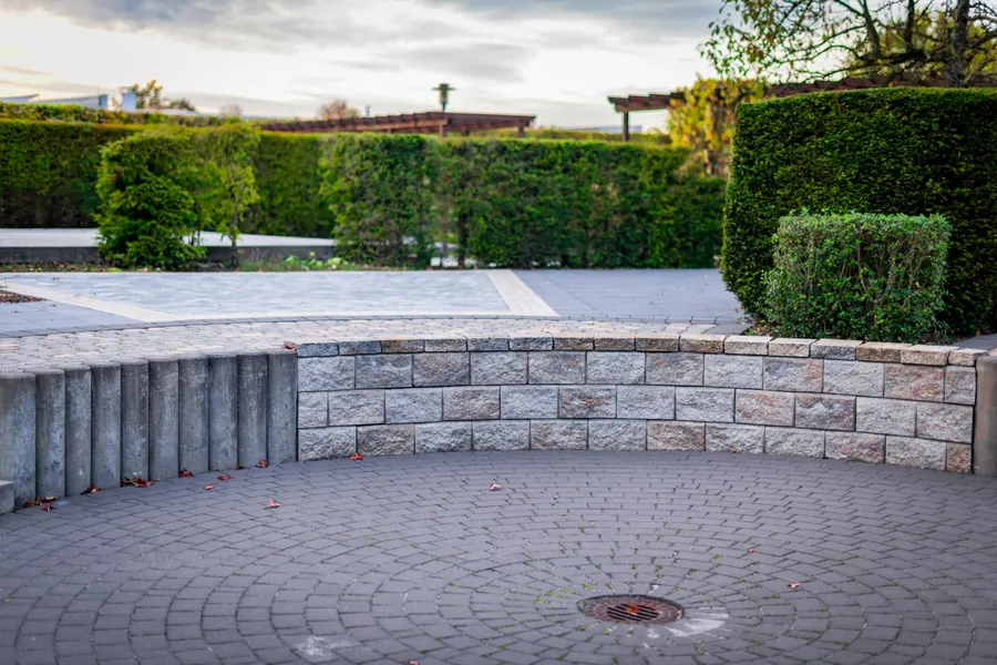 Curved block retaining wall around a paved courtyard