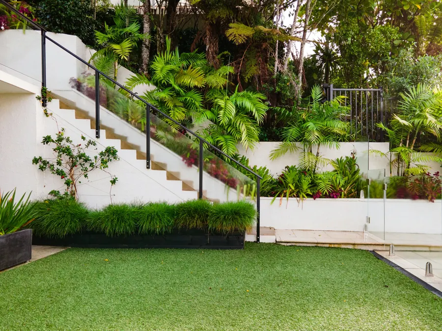 Terraced garden with rendered retaining walls, stairs and a level lawn