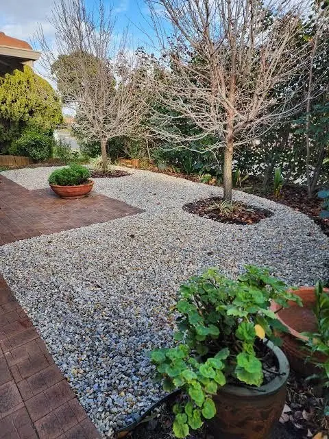 Front garden with brick paving, decorative gravel and mulched tree surrounds